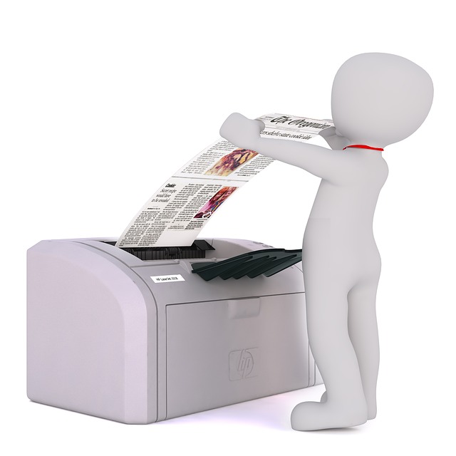 muž vytahující papír z tiskárny